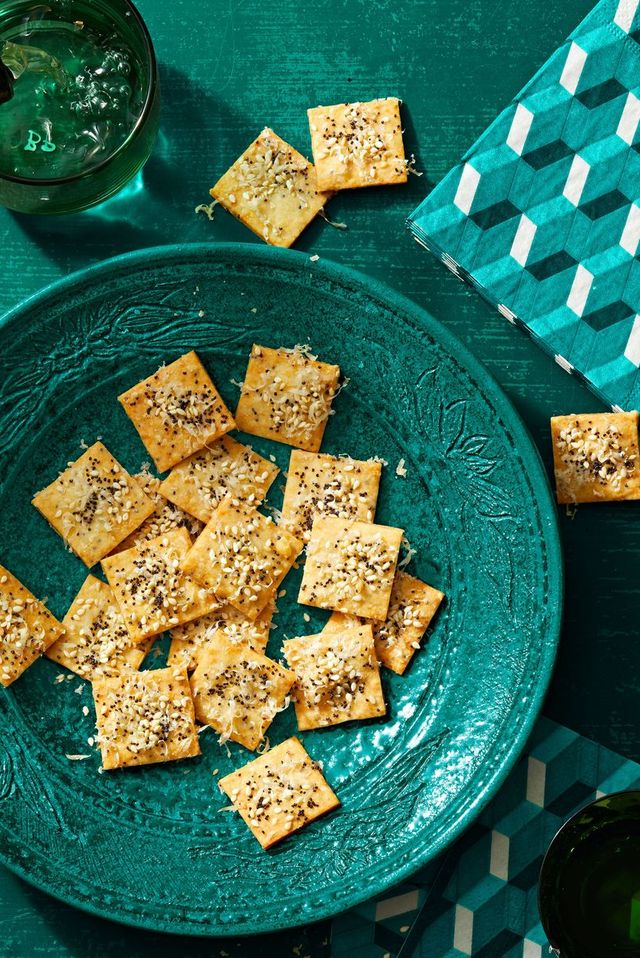 parmesan seeded crackers in a teal ceramic bowl