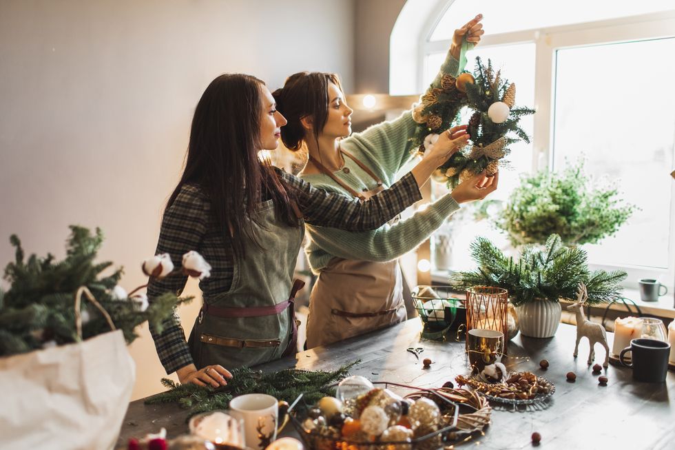 two-women-making-christmas-wreath-using-fresh-pine-royalty-free-image-1698246699
