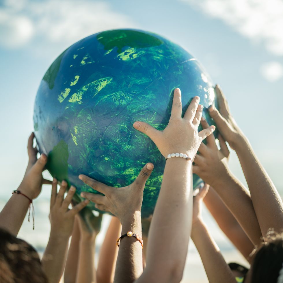 close-up-of-children-holding-a-planet-at-the-beach-royalty-free-image-1712341816