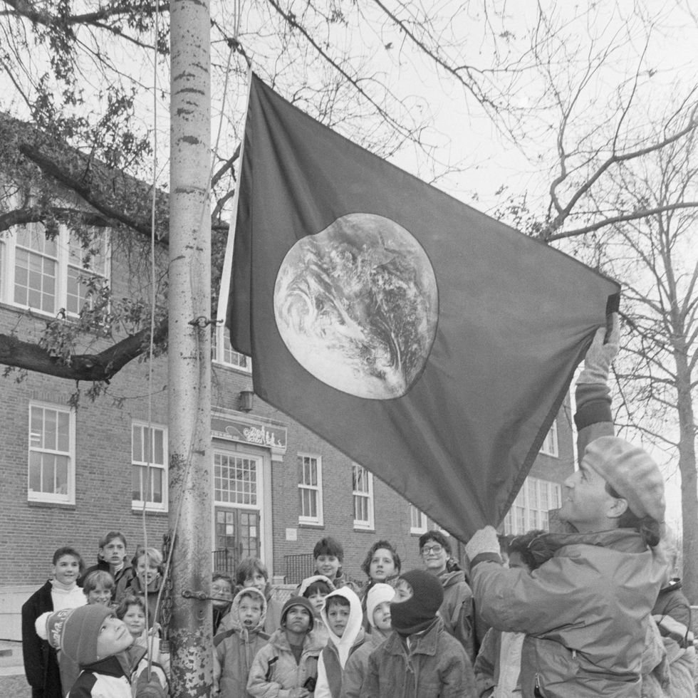 children watch as the earth day flag is raised