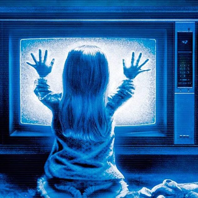 carol anne puts both hands on a staticky tv in a scene from 'poltergeist,' a good housekeeping pick for best halloween movies