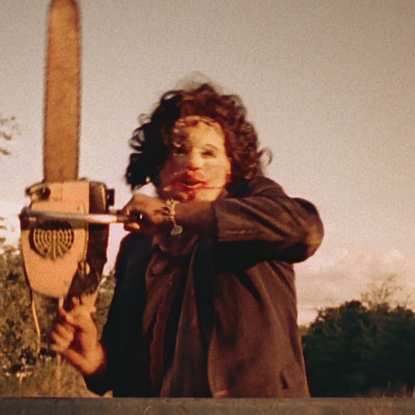 leatherface holds up a chainsaw in a scene from the texas chainsaw massacre, a good housekeeping pick for best halloween movies