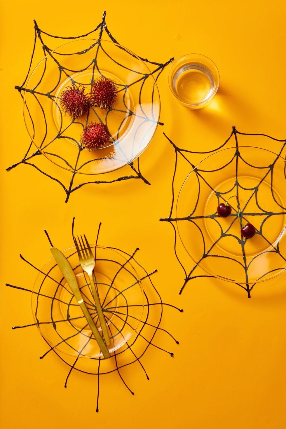 halloween crafts, three webbed placemats with clear plates on top