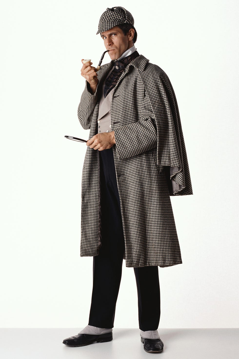 man dressed as sherlock holmes against a white background