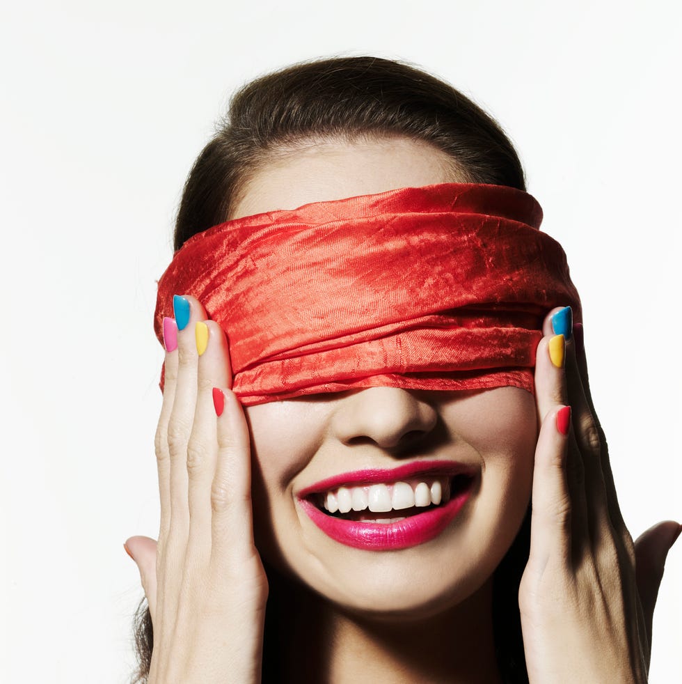 girl with bright nail polish blinded with a red scarf covering her eyes