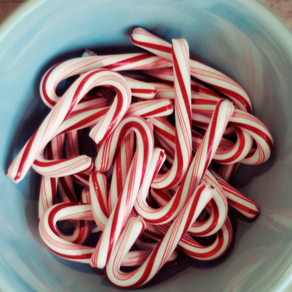 a bunch of mini candy canes in blue bowl