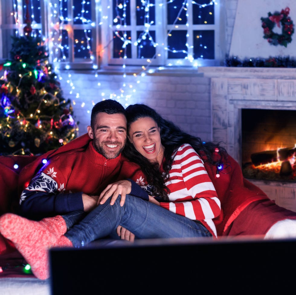 man and woman watching movies at christmas time