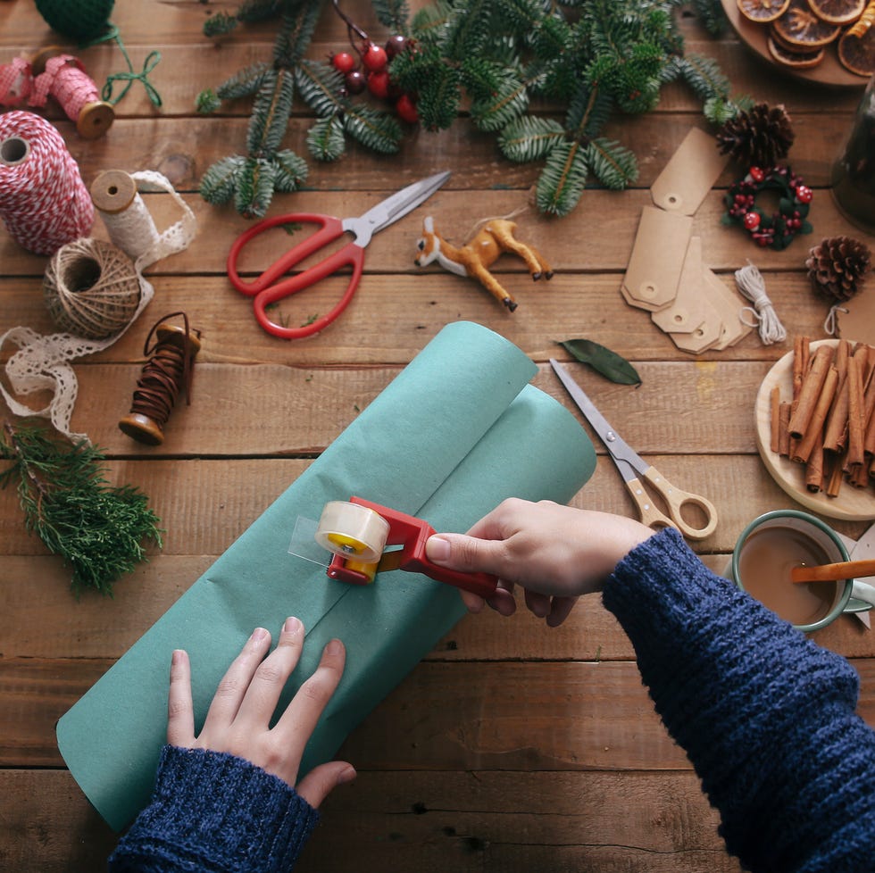 two hands wrapping a christmas present