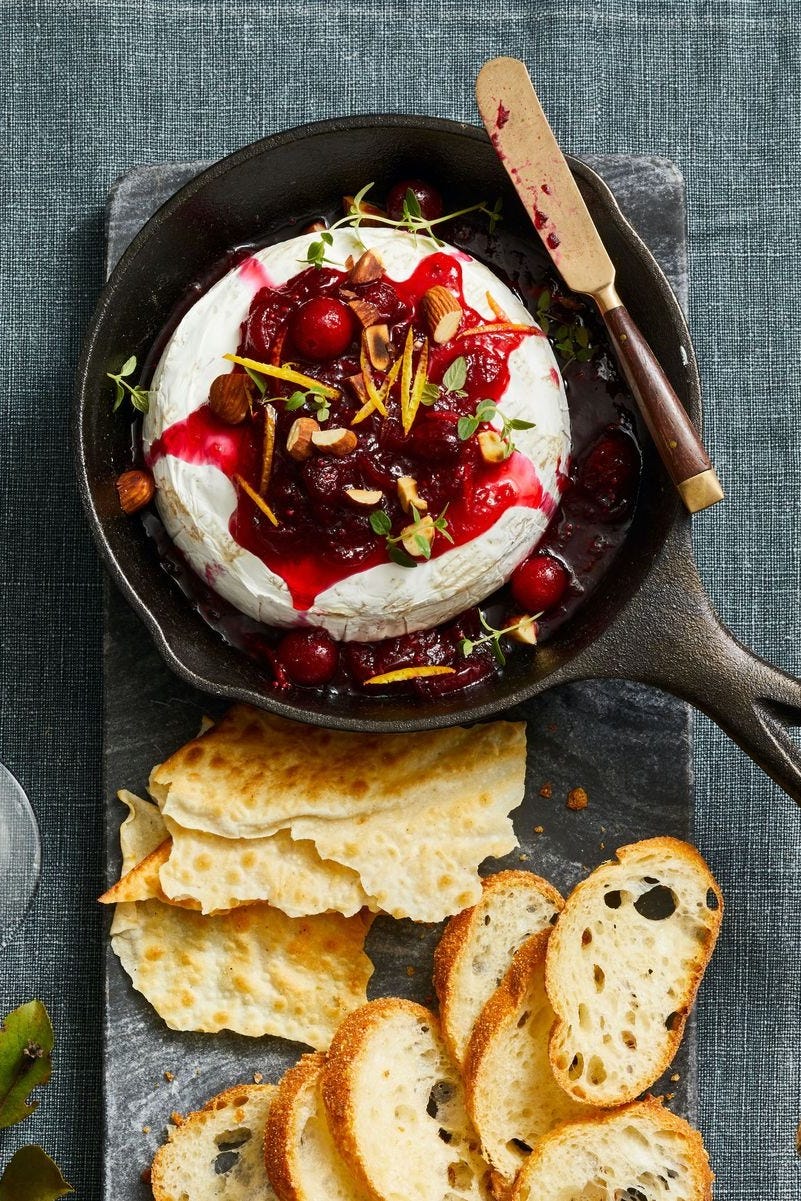 baked brie with cranberry syrup on top in a mini cast iron pan