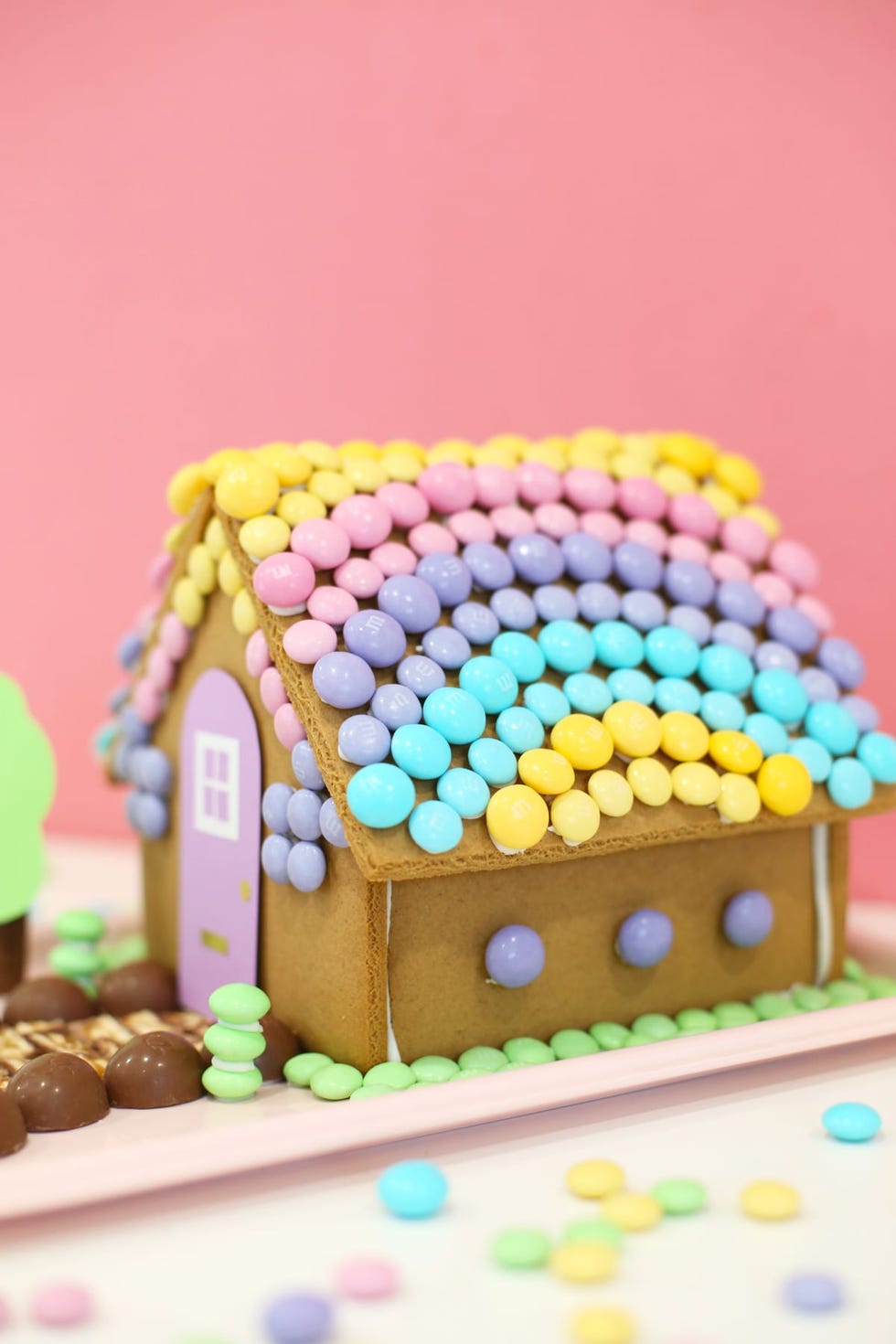 a gingerbread house decorated with pastel m and ms