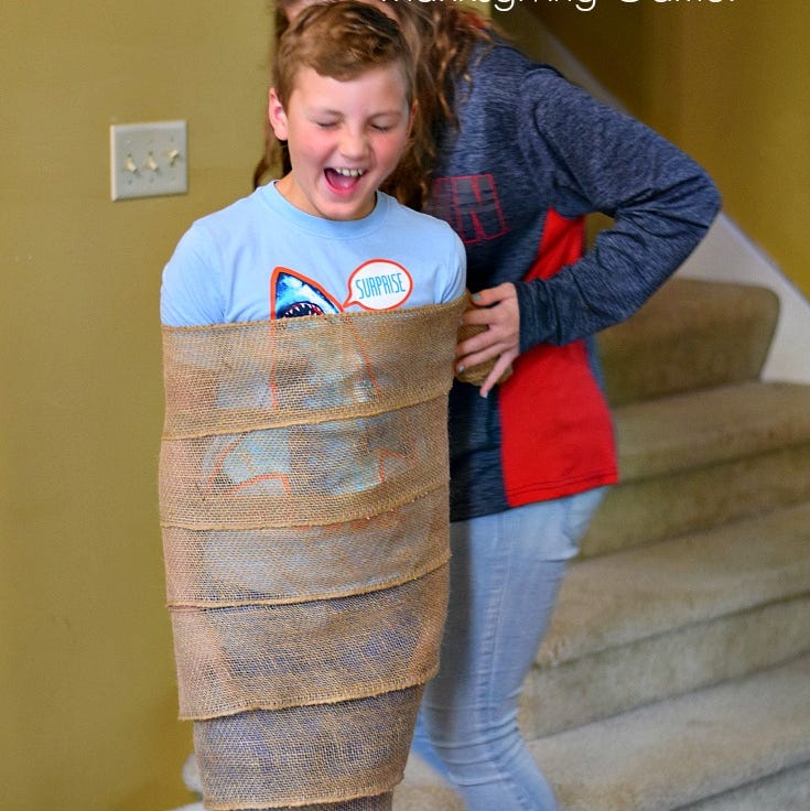 kids playing turkey leg wrap game with burlap