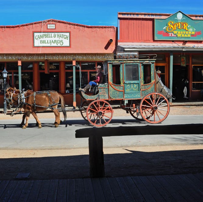 a stagecoach takes paying customers on a horse drawn tour of historic tombstone, arizona