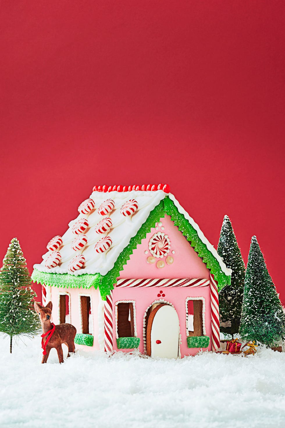 a pink and peppermint covered gingerbread house