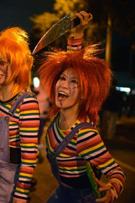 woman with red hair, overalls and halloween makeup to look like chucky doll