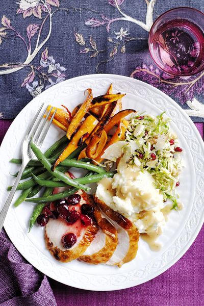 thanksgiving turkey dinner plate with turkey, mashed potatoes, green beans, salad and roasted vegetables