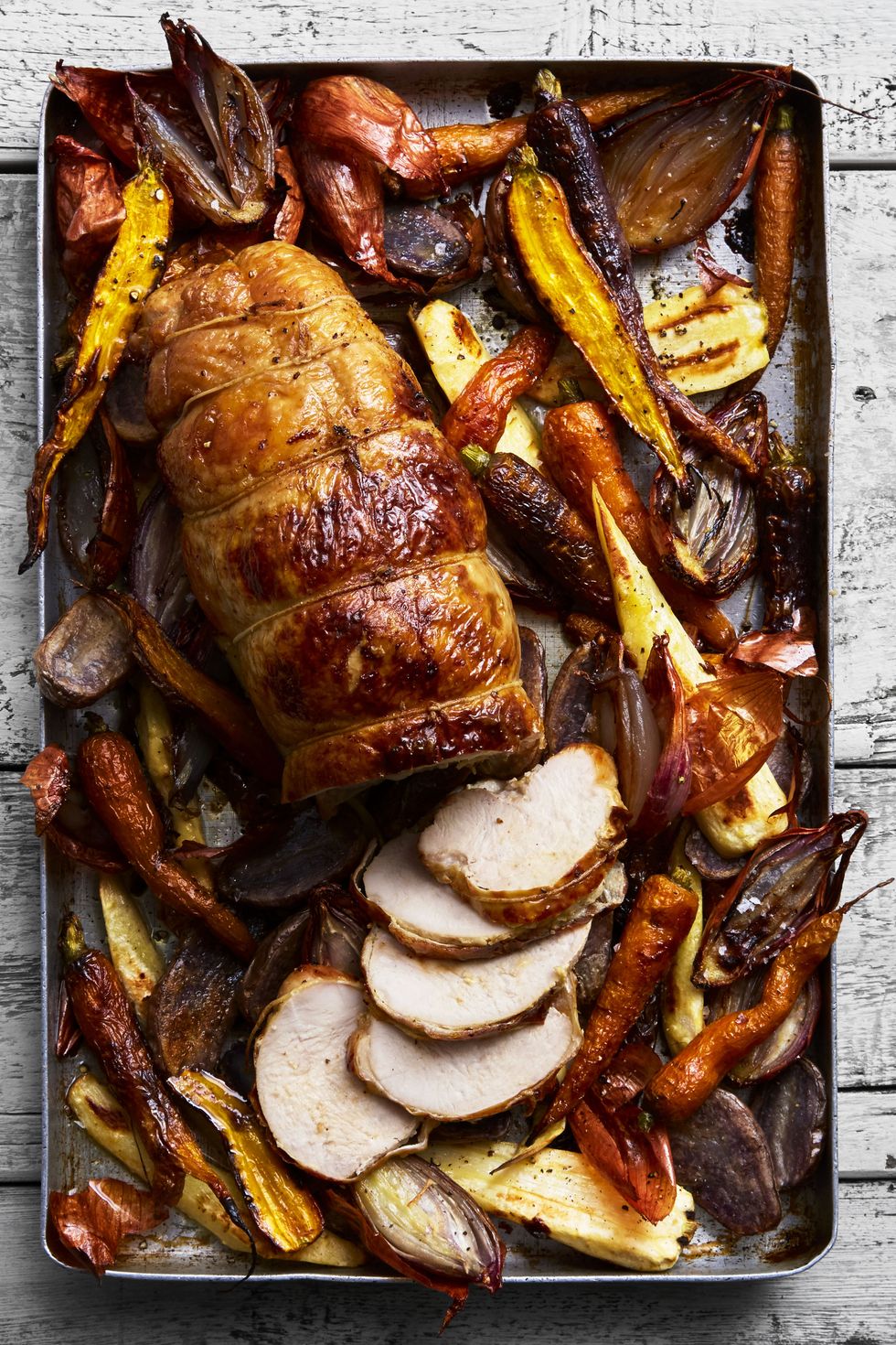 roasted turkey breast and root veggies on a baking pan