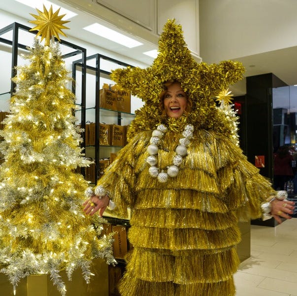 a genie played by melissa mccarthy wears a christmas tree outfit in a scene from genie