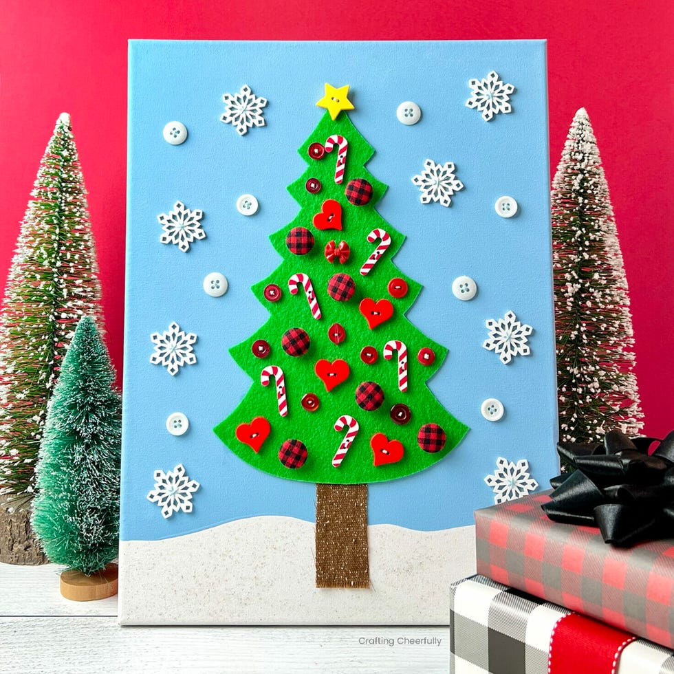 craft display of a decorated christmas tree on a blue background with snowflakes