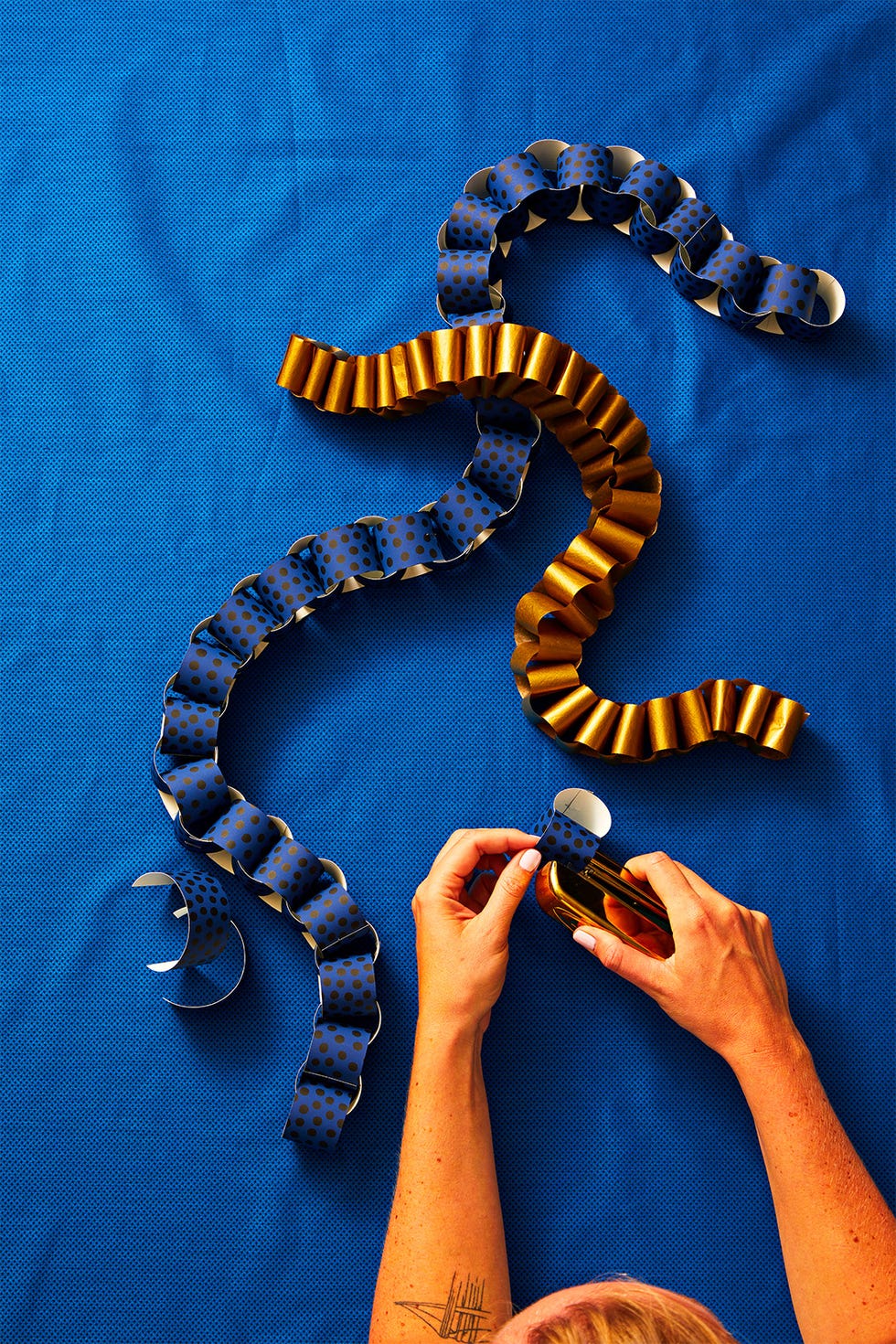 crafting with colorful paper loops on a blue surface