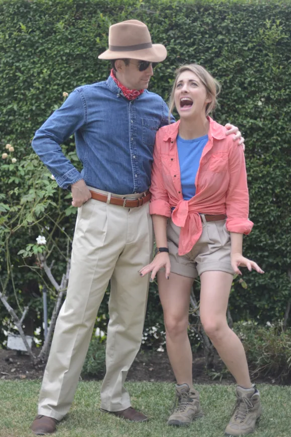 a couple dressed as grant and ellie from jurassic park standing outside near bushes the costume idea is a good housekeeping pick for best 90s halloween costumes