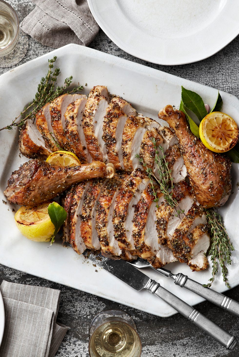 sliced roast turkey with herbes de provence on a white serving platter