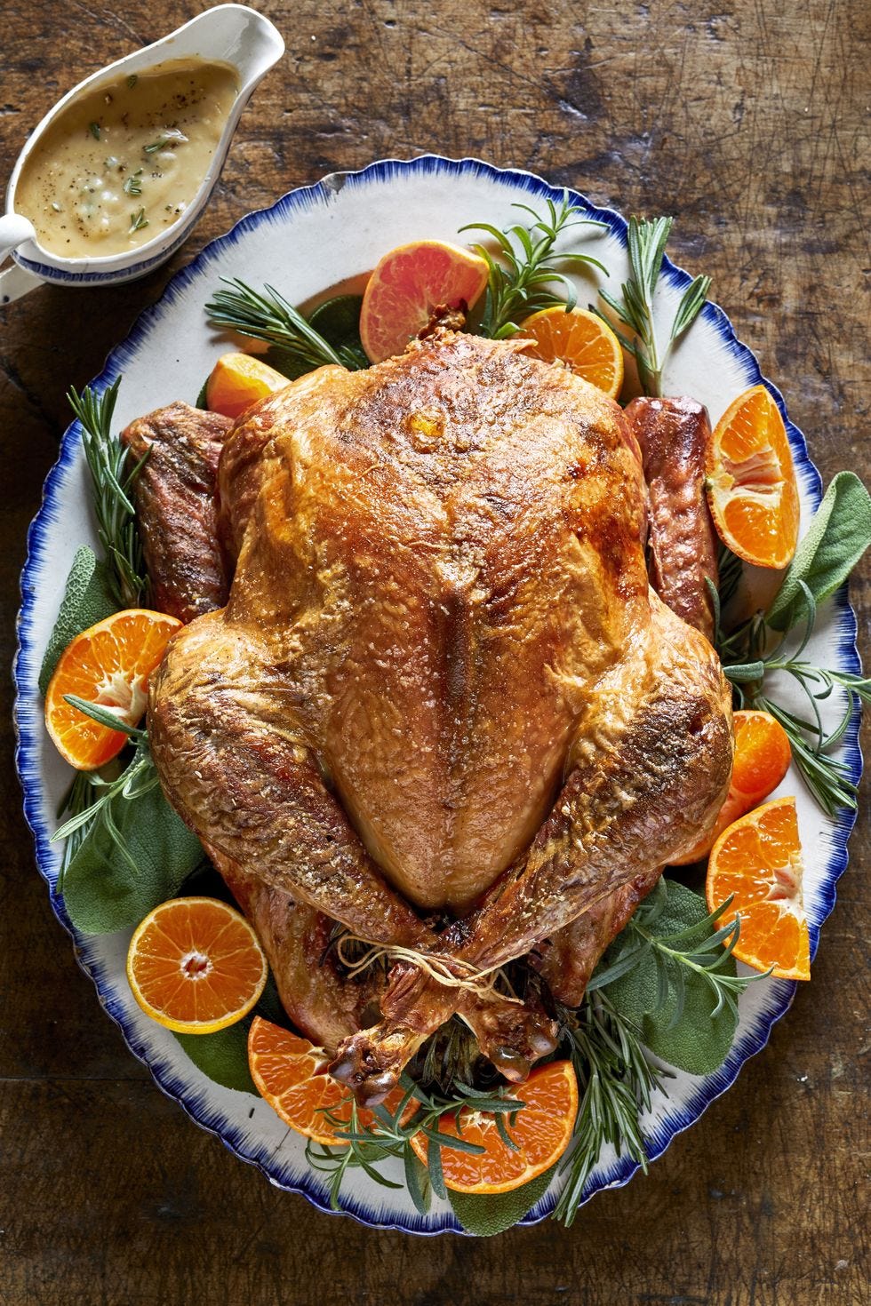 seasoned roasted turkey on a serving platter with orange slices