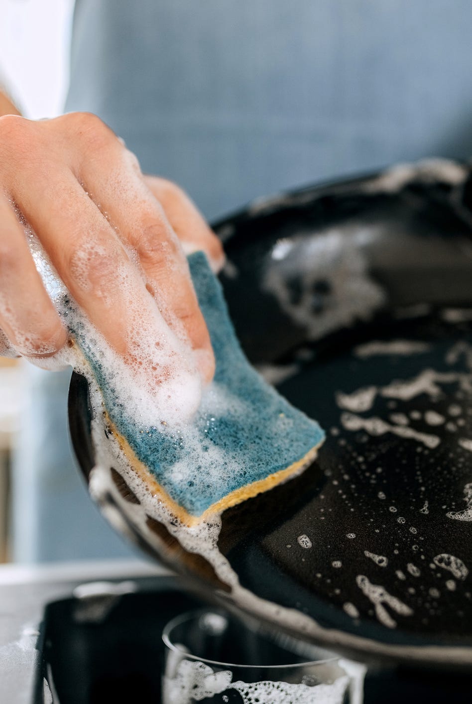 close up shot of man washing cooking pan