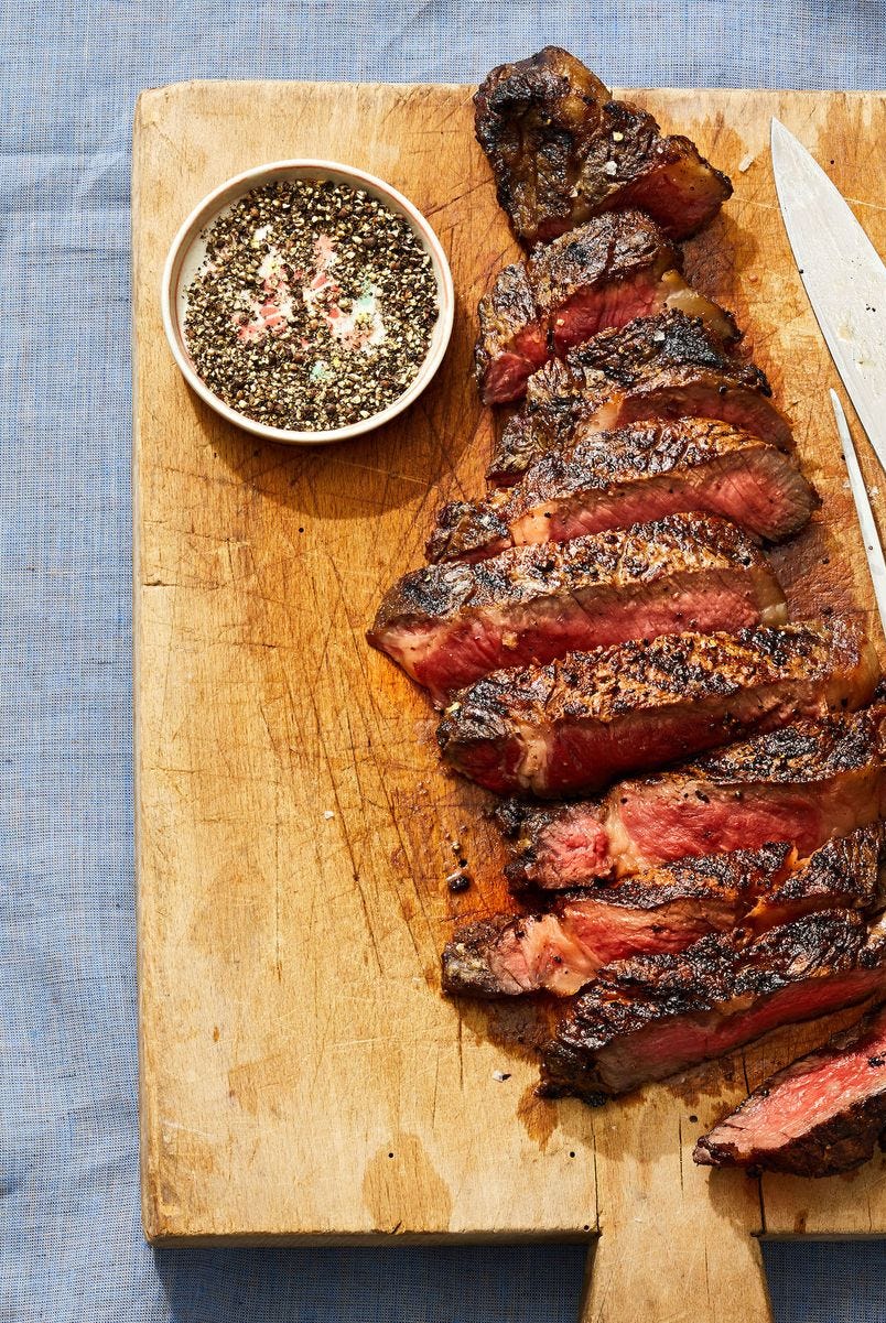 grilled rib eye sliced on a wooden cutting board