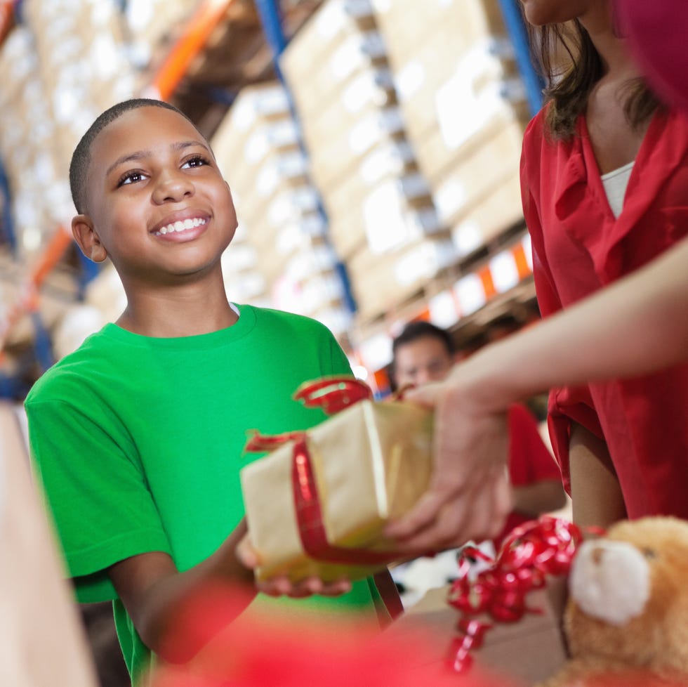 little boy donating christmas present at charity toy donation drive