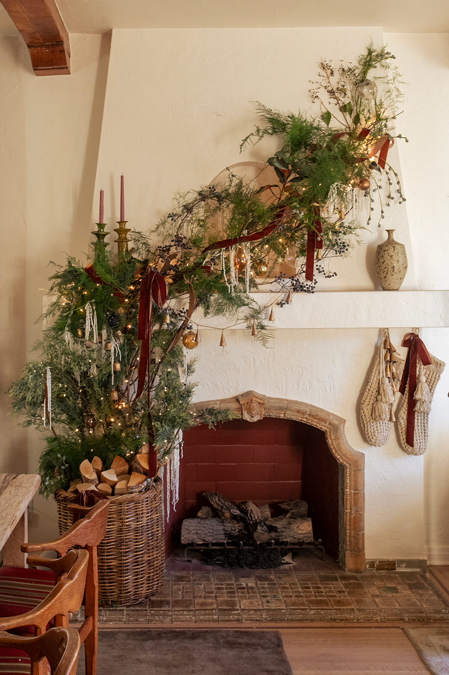 christmas mantel decorated with greens and burgundy ribbons