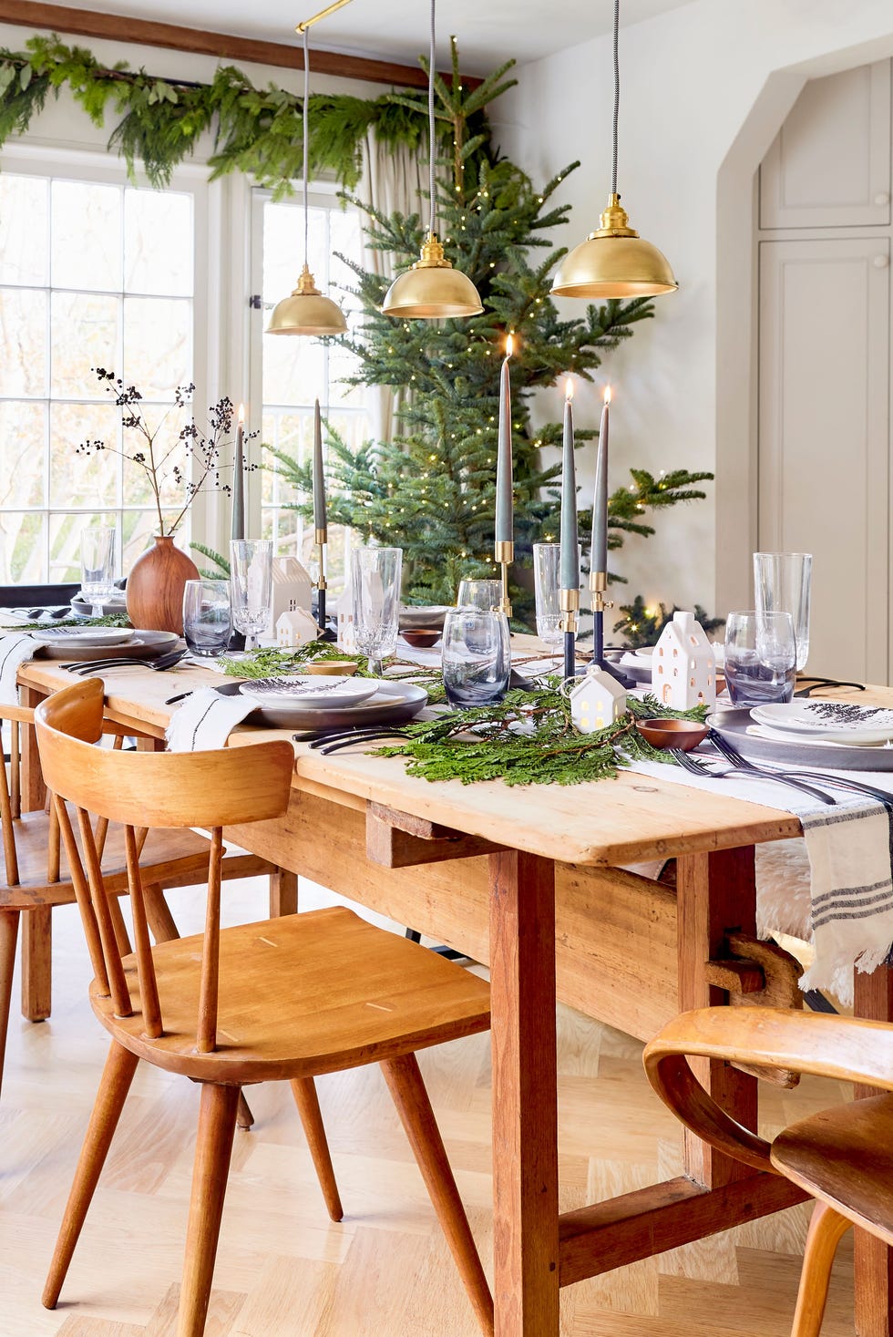 wood dining set with taper candles and greenery