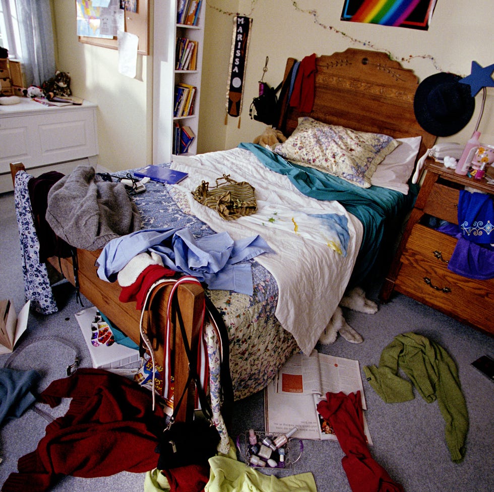 bedroom with clothes, books and cds thrown around