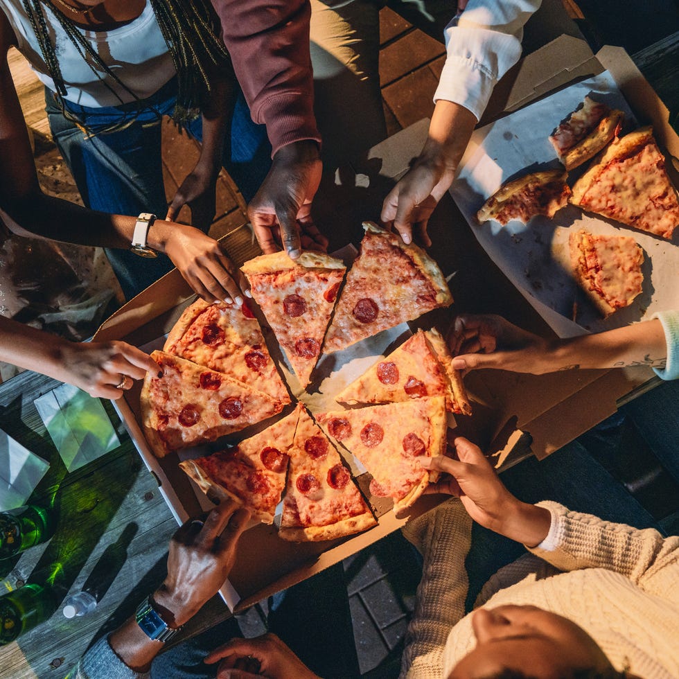 high angle view of people taking pizza slices