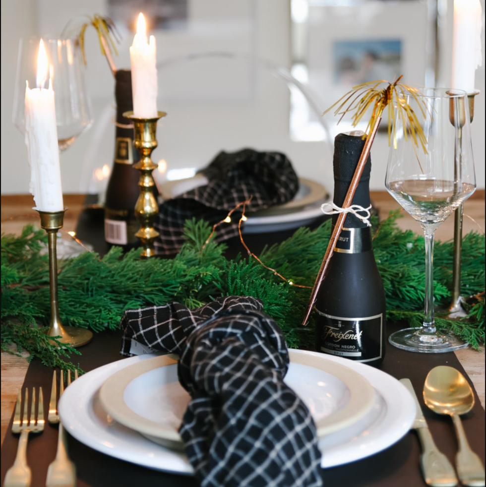 a table with a plate and glasses and a bottle of wine