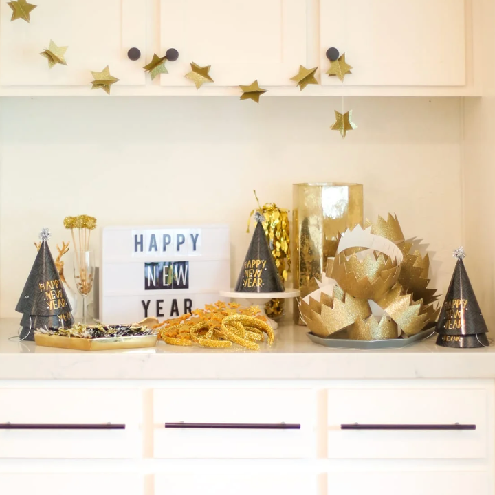 a white cupboard with a collection of party hats and crowns displayed on it