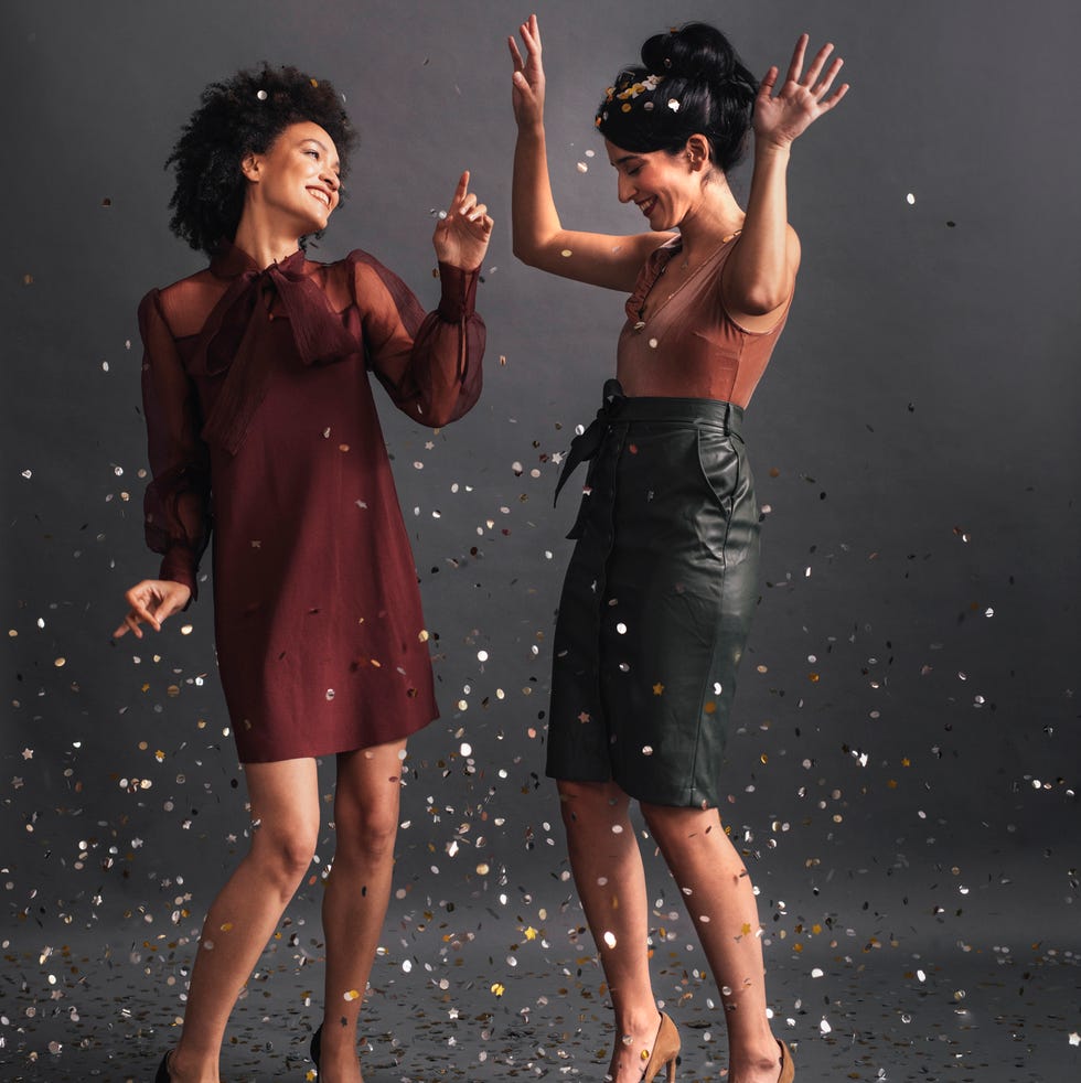 dancing in confetti two elegant women dancing together at a party studio shot, copy space