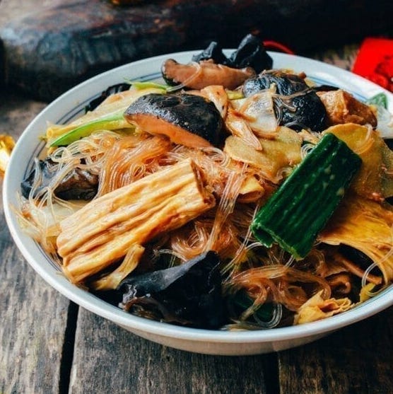 a bowl of stirfried noodles with vegetables and ingredients