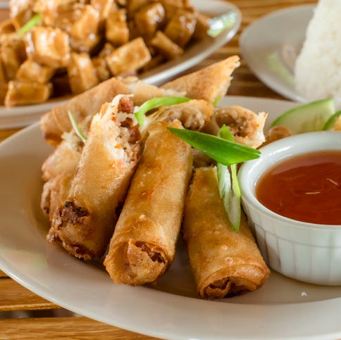 lumpiang shanghai, a filipino egg roll, with sizzling tofu and a cup of rice at the back philippine cuisine