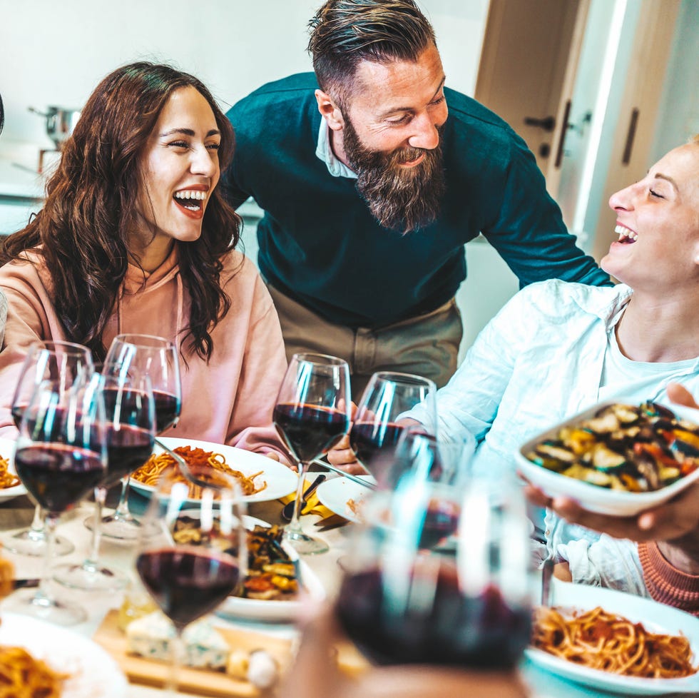 happy group of friends having dinner party at home