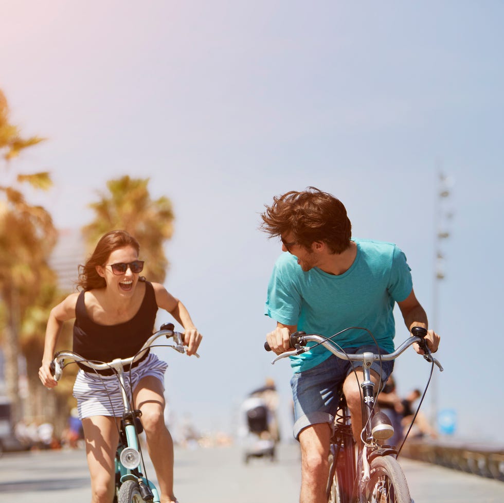 woman and man riding bicycles in some tropical location