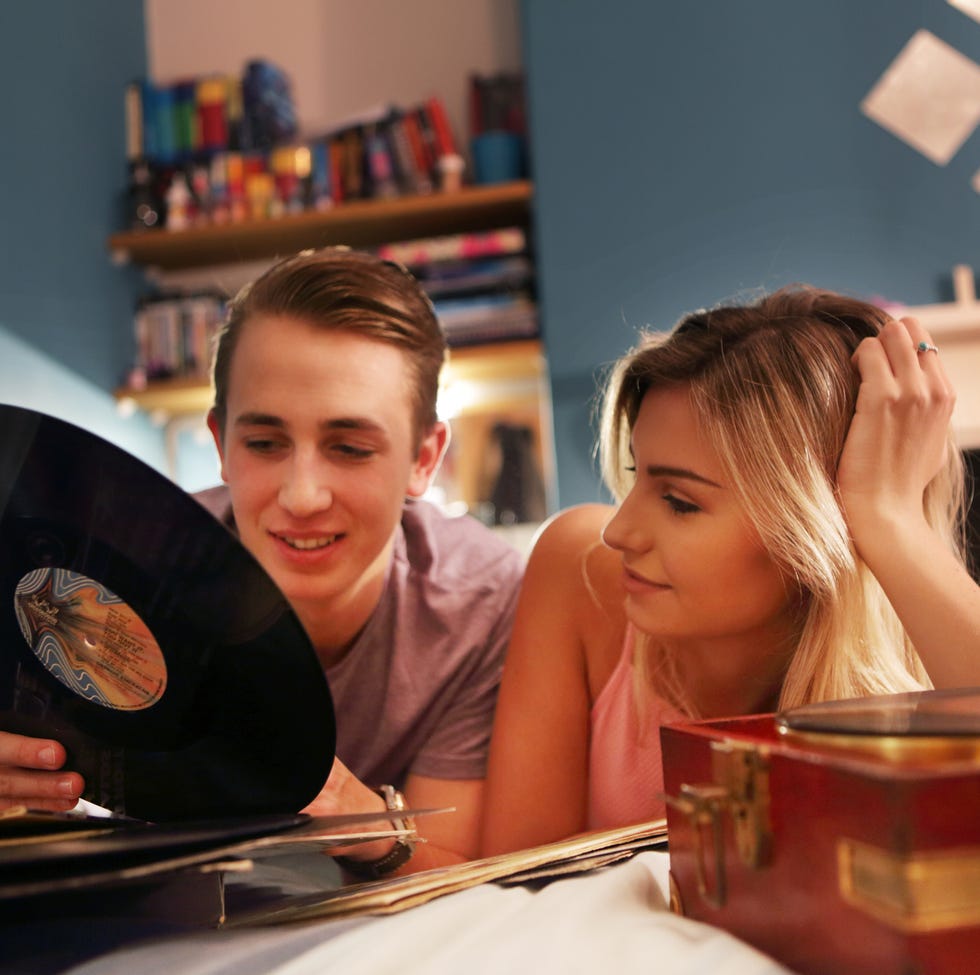 young couple in bedroom with record player